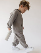 Kid carrying Elevated Faith Kids Water Bottle while wearing Christian Kids Apparel in gray outfit
