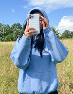 Christian iPhone Case featuring inspirational text held by a person in a blue hoodie outdoors