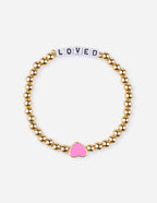 Elevated Faith Christian Jewelry Bracelet with gold beads and a pink heart charm that says LOVED