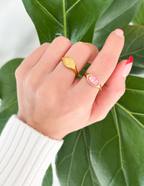 Elevated Faith Christian Jewelry rings displayed on a hand with colorful accent and leafy background