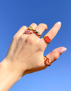 Colorful rings on hand showcasing Elevated Faith designs, perfect for Christian Jewelry lovers.