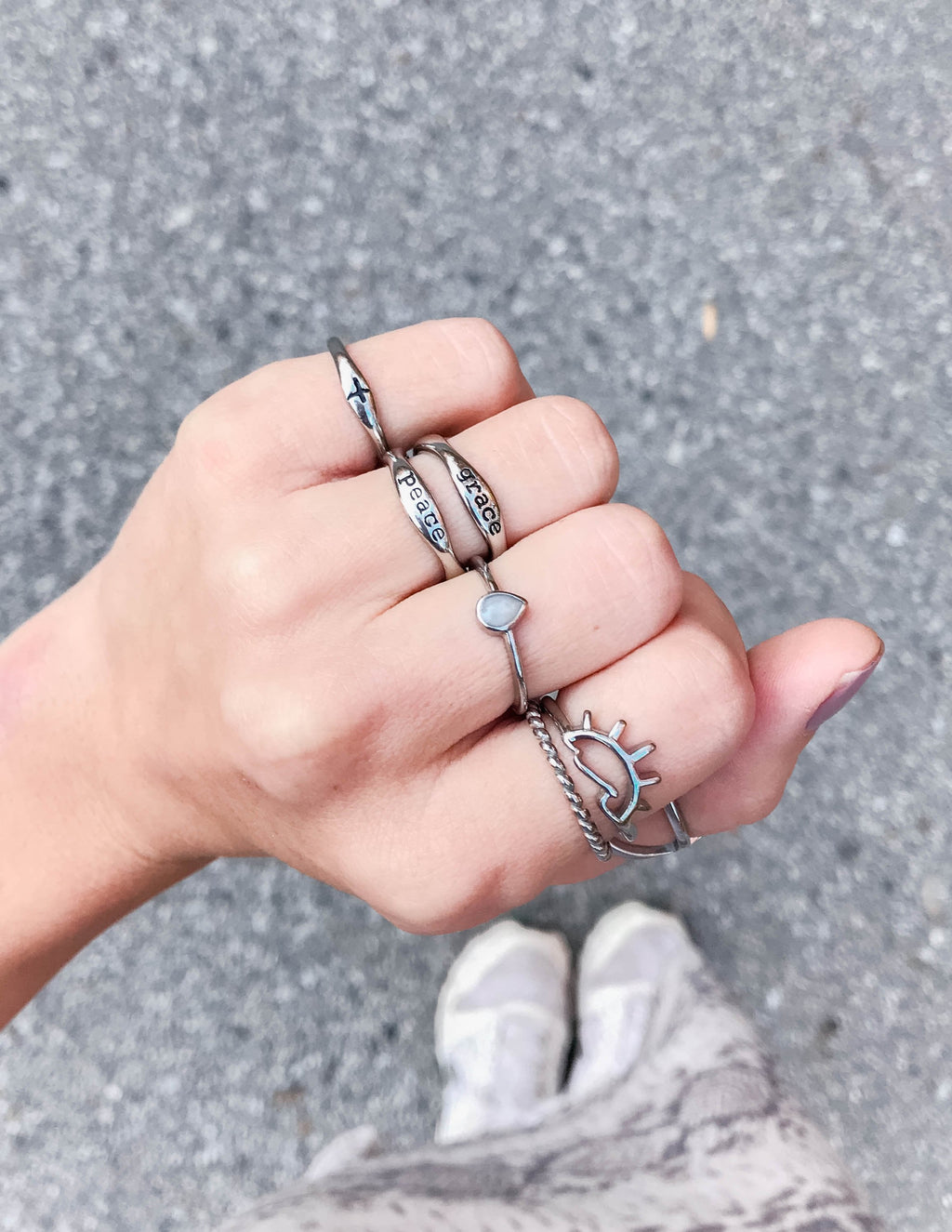 Collection of Elevated Faith Christian Jewelry rings displayed on a hand with various designs