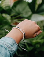 Elevated Faith Christian Jewelry Bracelet showcased on a model's wrist against a lush green background