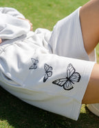 Elevated Faith Christian Shorts in light gray featuring butterfly graphics on the side