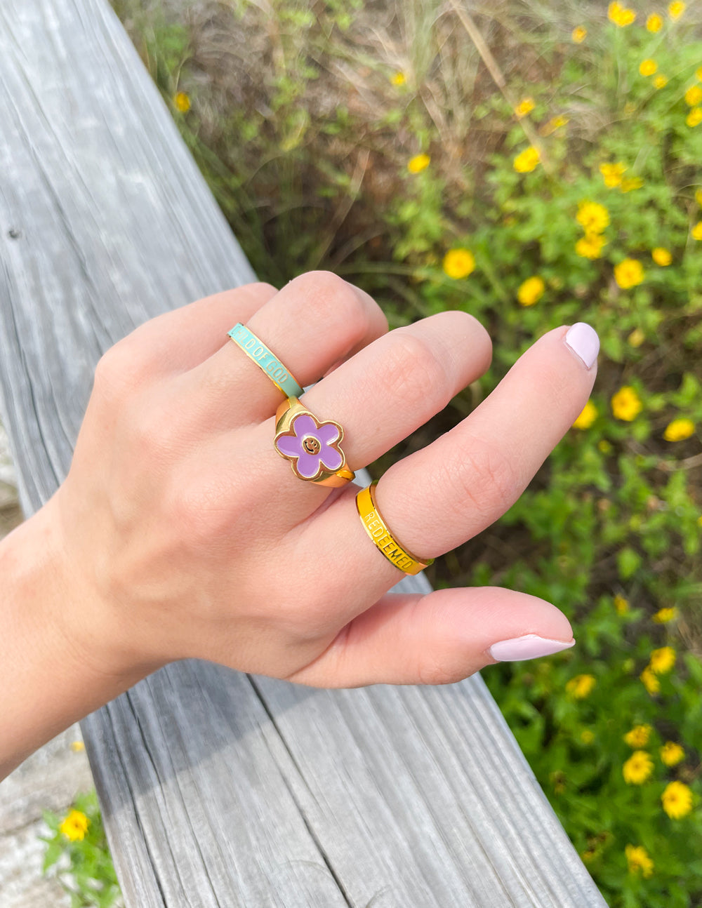 Colorful Elevated Faith Christian Jewelry Rings on a hand with floral and inspirational designs